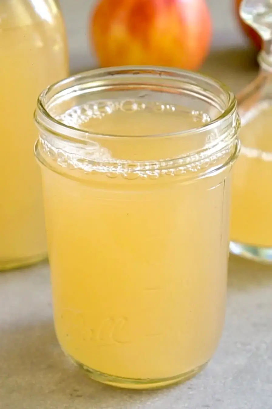 Glass jar of finished apple cider vinegar with floating mother and sediment